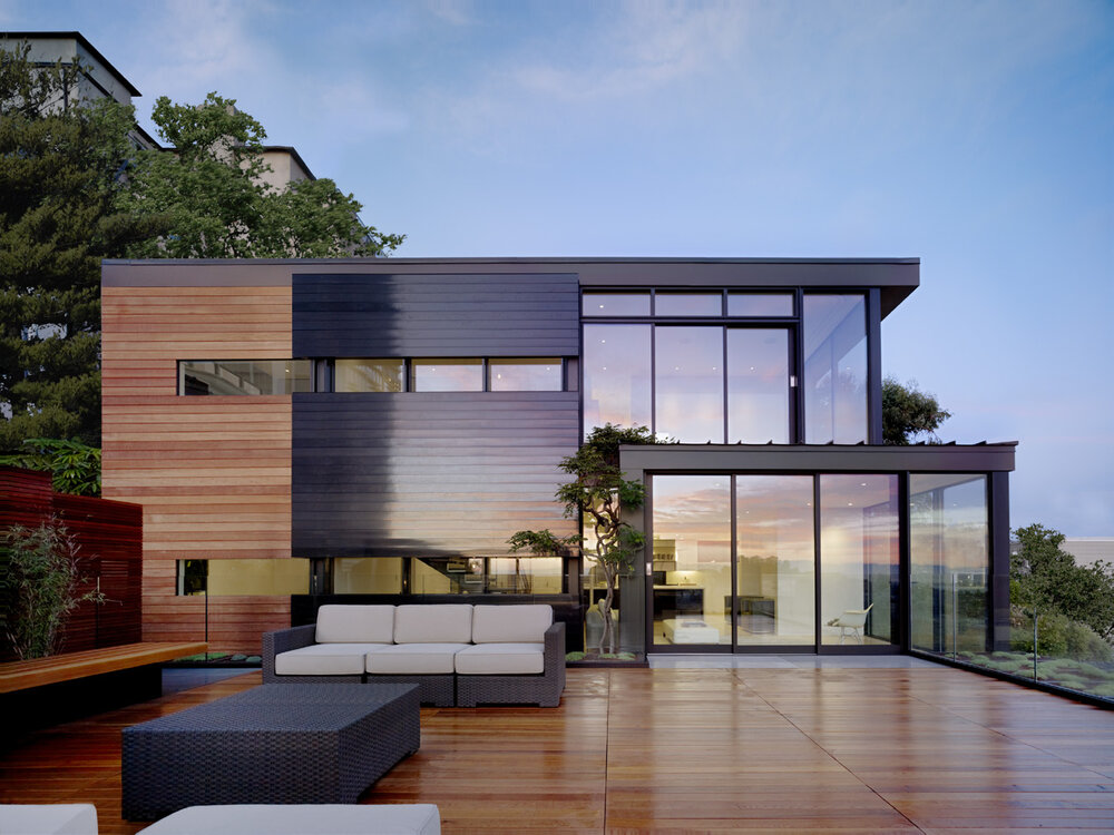 Exterior of a house with deck seating and a pool.